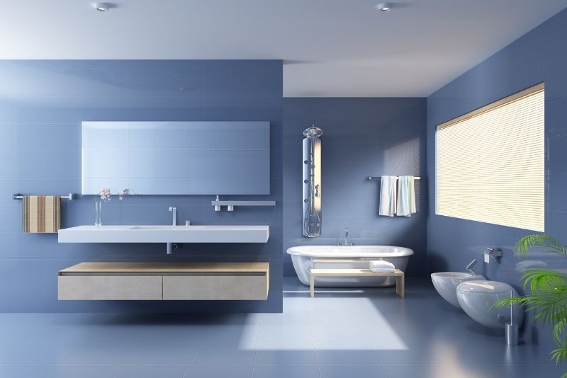 Blue-tiled bathroom with a floating vanity, freestanding bath and bidet