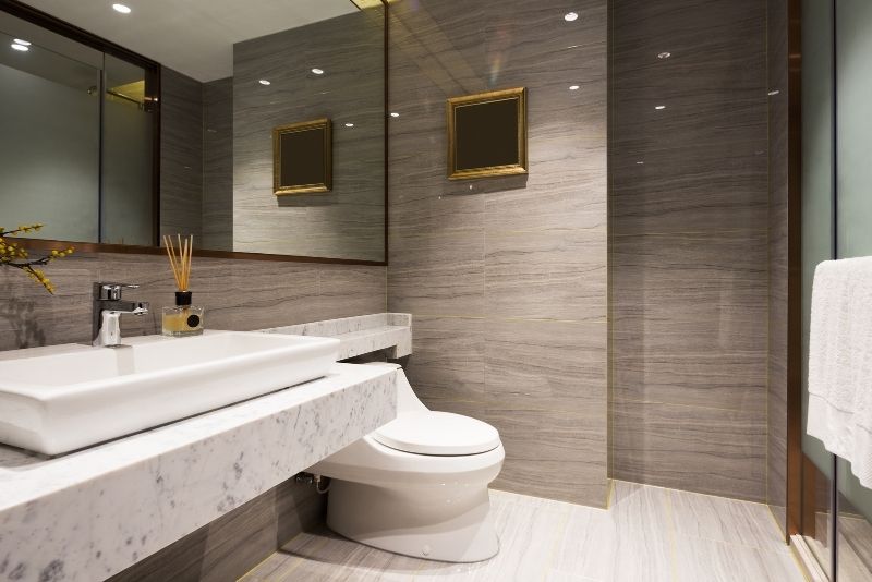 elegant and stylish bathroom with brown wall and marble tile sink