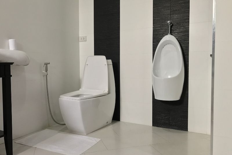 White and black bathroom with a urinal