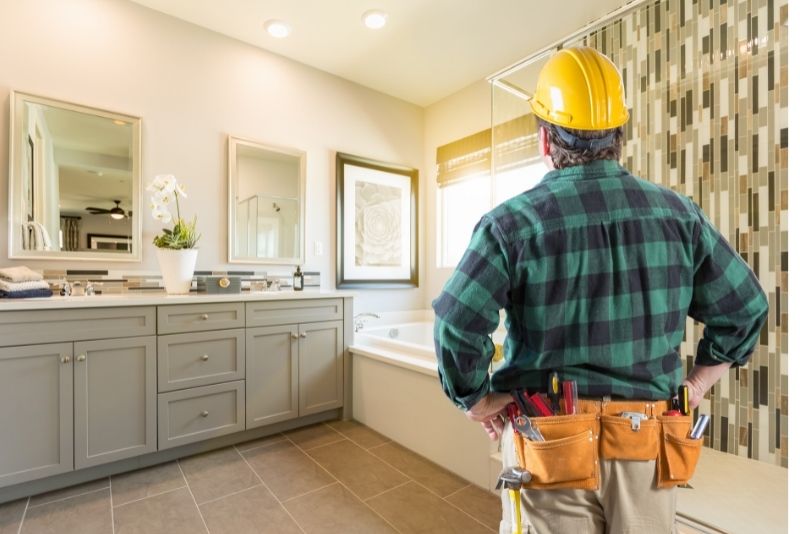 A contractor assesing the bathroom for a renovation