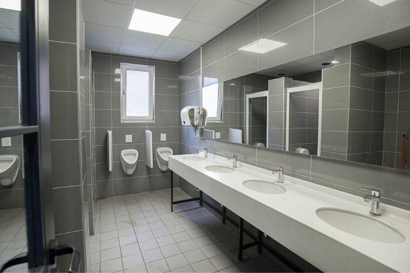 A commercial bathroom with grey walls