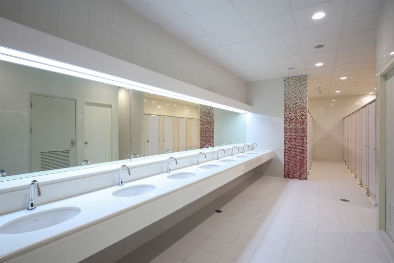 A commercial bathroom with white sinks