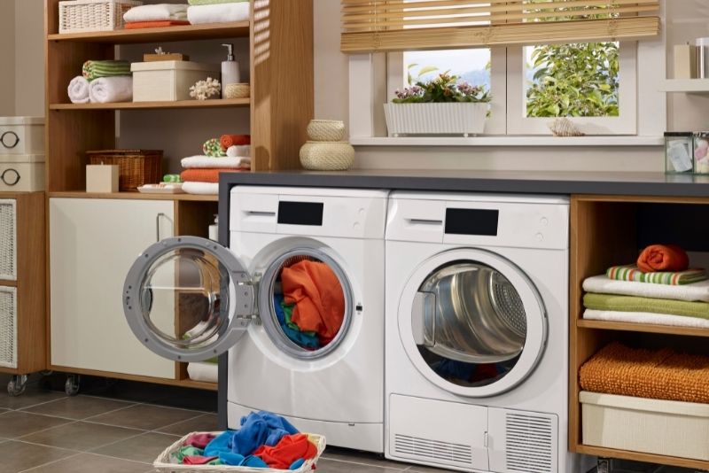 A laundry room fitted with cabinets and appliaces