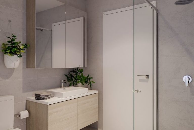 Bathroom with a timber vanity, potted plants and a framed glass shower screen